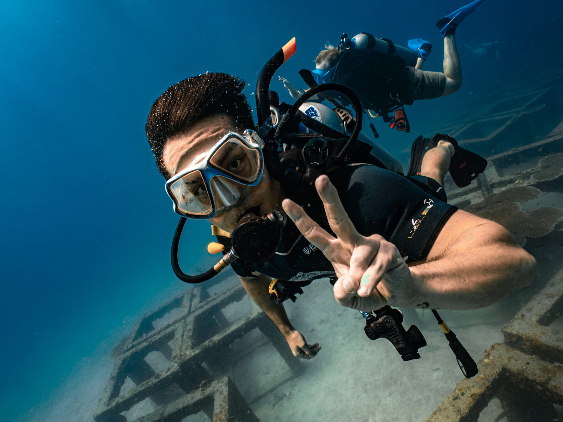 Diver giving OK sign over a wreck, Koh Tao